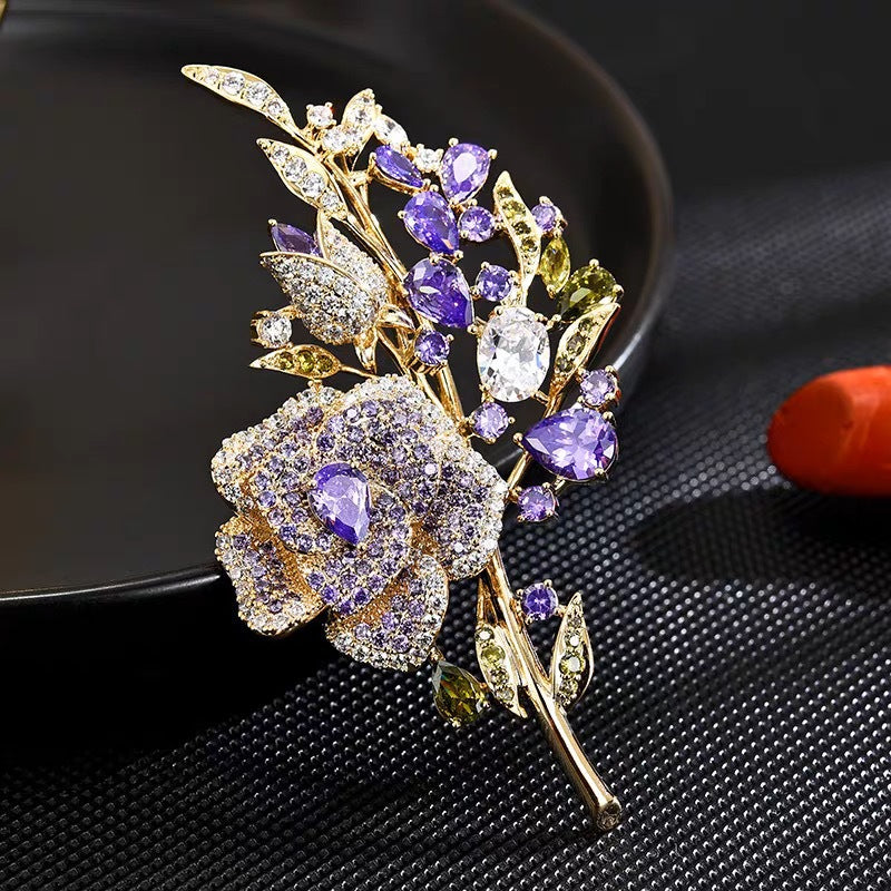 Purple rose brooch displayed on fabric