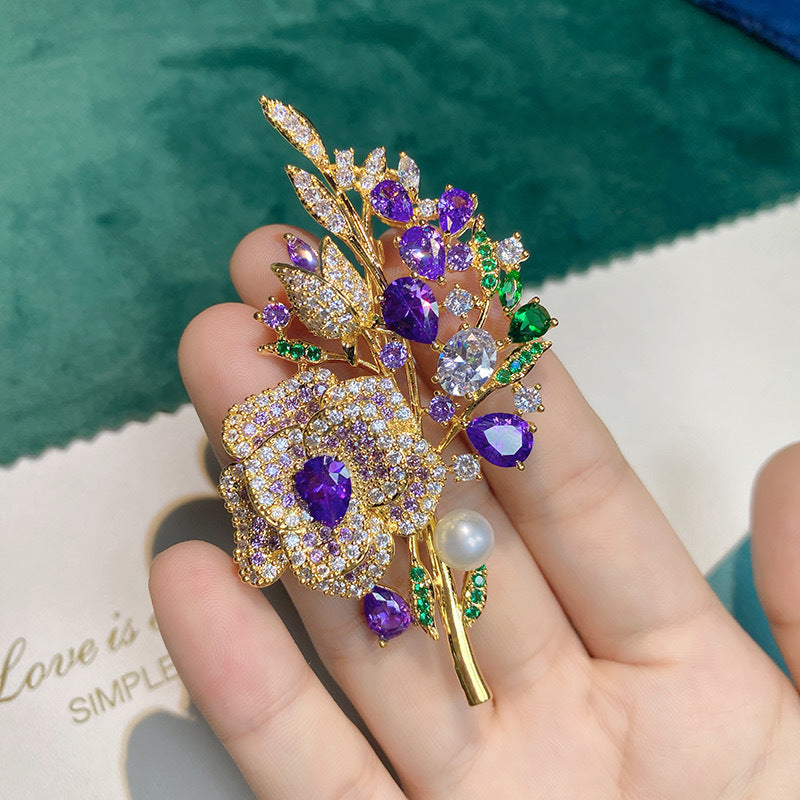 Purple rose brooch displayed on fabric