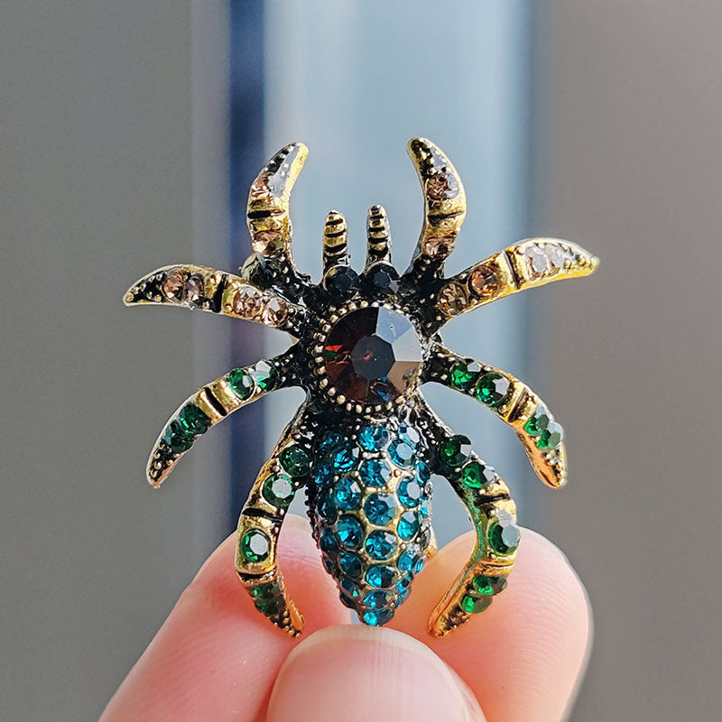 Trendy spider brooch with cat eye stones on a white background