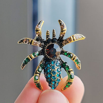 Trendy spider brooch with cat eye stones on a white background