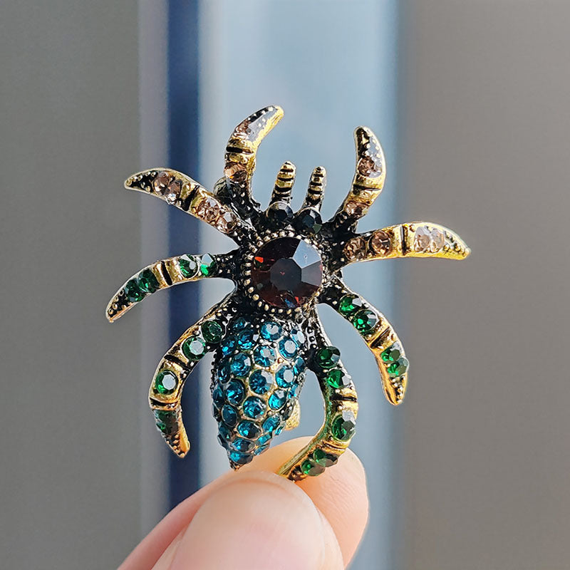 Trendy spider brooch with cat eye stones on a white background