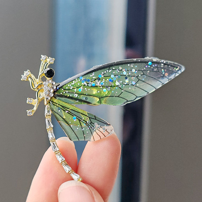 Multiple colors of dragonfly brooch laid out for choice