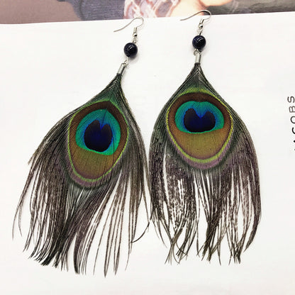 Close-up of stylish tassel earrings showcasing peacock feathers