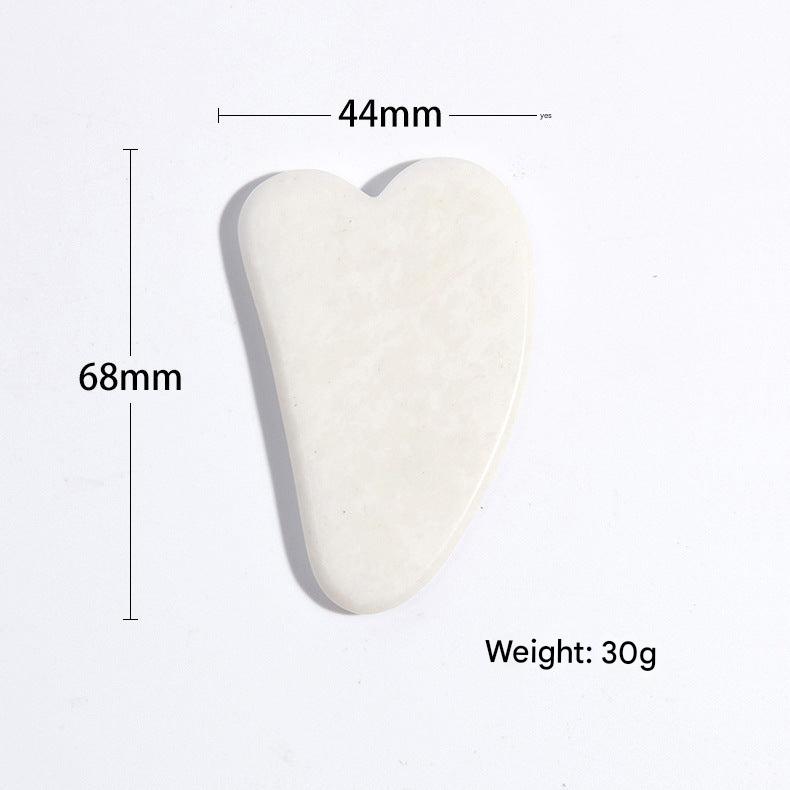 Close-up of jade roller and gua sha set on white background