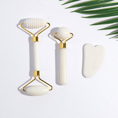 Close-up of jade roller and gua sha set on white background