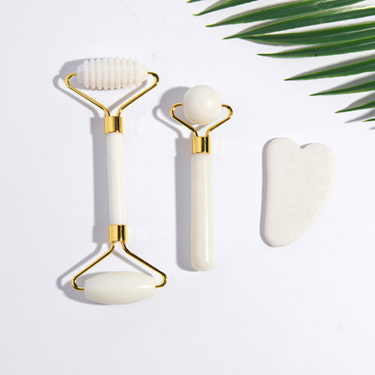 Close-up of jade roller and gua sha set on white background